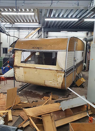 En bild på en trasig husvagn.